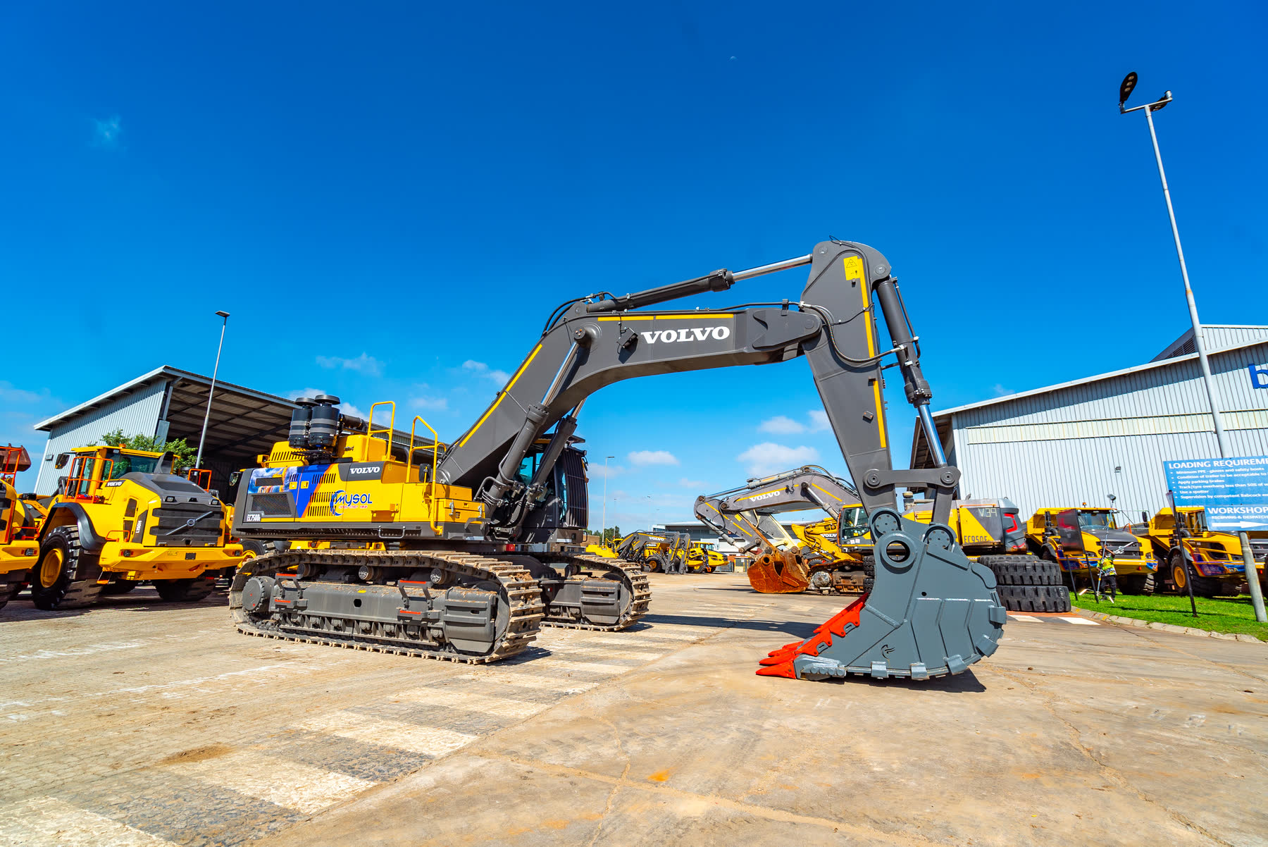 Loader bucket loading material into dump truck.