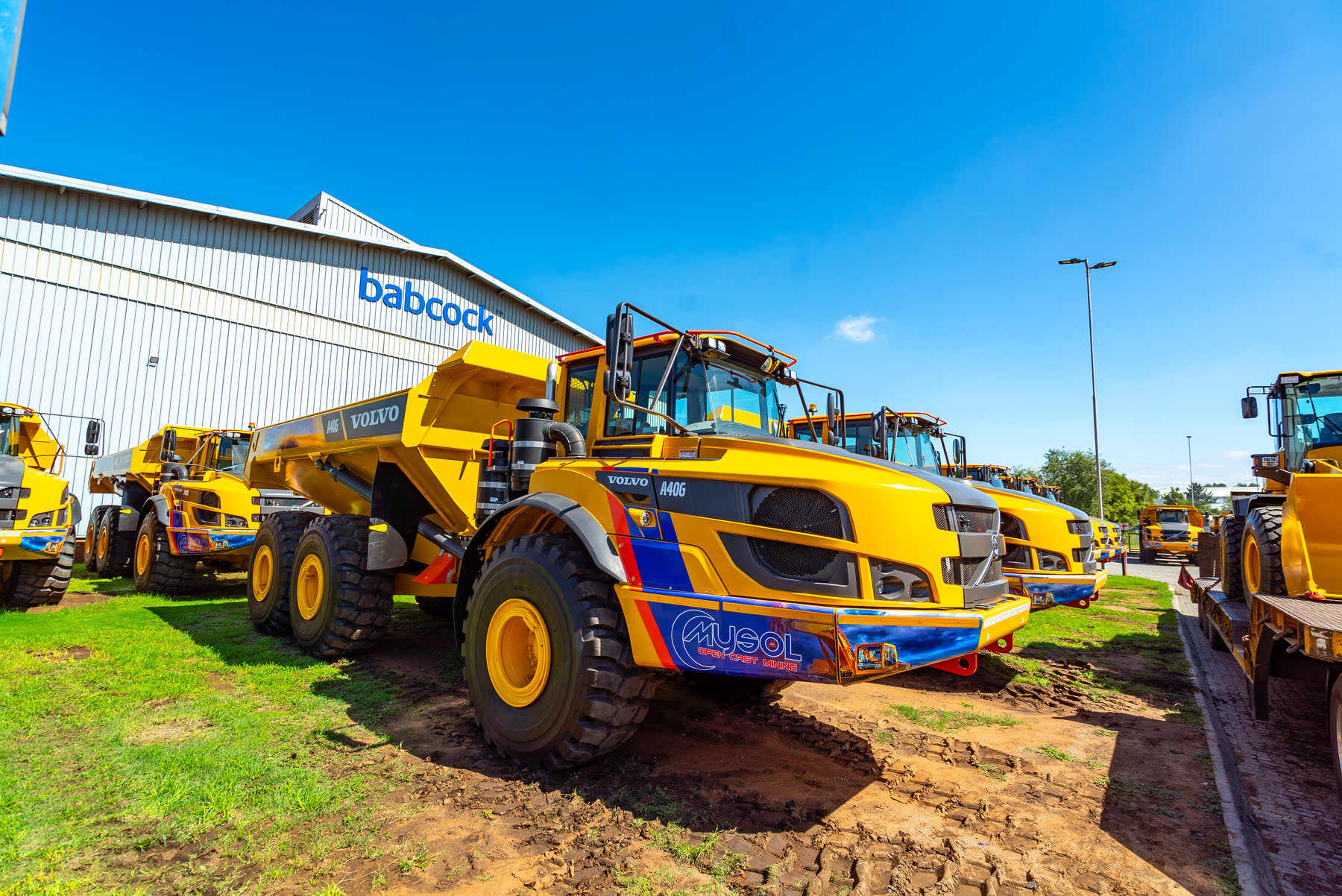 Articulated dump truck carrying load out of pit.