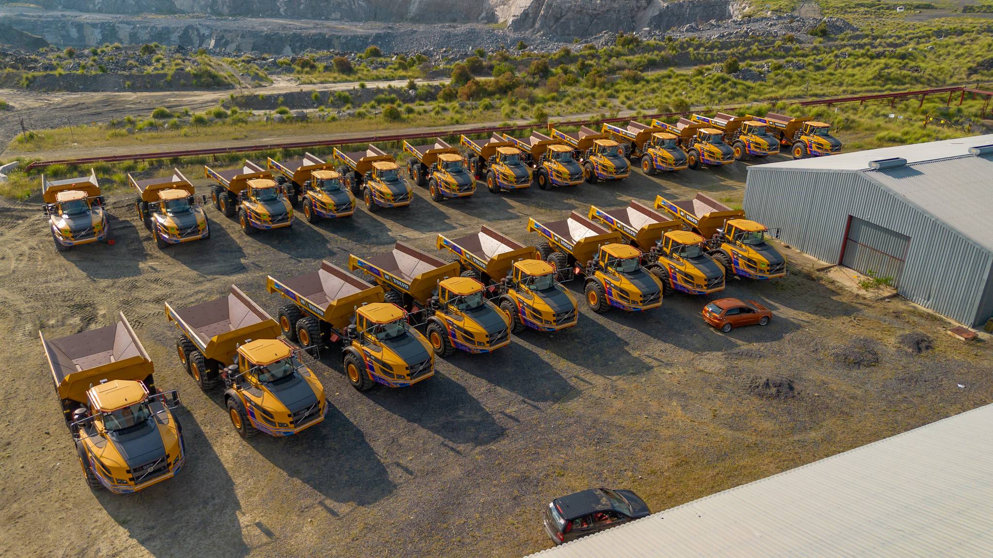 Articulated dump truck and loader moving materials.